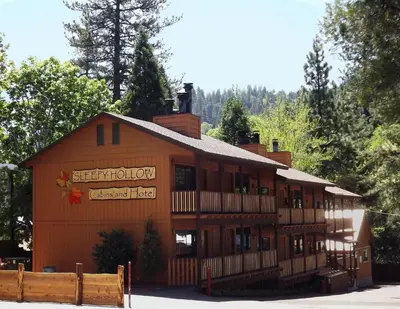 a large brown building with a sign on it at Sleepy Hollow Cabins and Hotel in Crestline