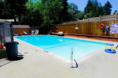 a large swimming pool in a backyard with a fence at Sleepy Hollow Cabins and Hotel in Crestline