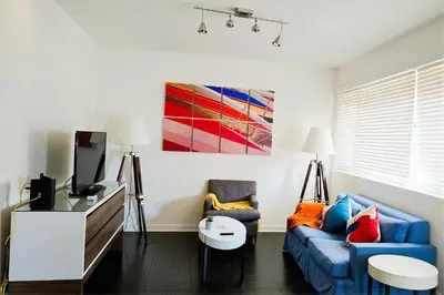a living room with a blue couch and a tv at Modern Venice Beach Stay - Walk to Marina & Boardwalk in Los Angeles