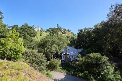 a house on the side of a hill with trees at Malibu Home in Enchanting Hills 5 min from the beach in Malibu
