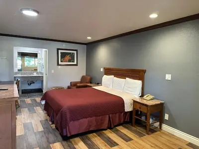 a hotel room with a bed and a desk at Corona inn in Corona