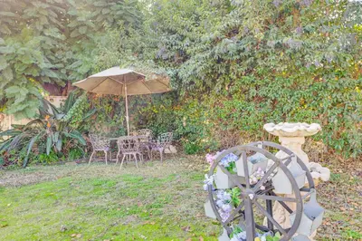 a garden with an umbrella and a table and chairs at 6 Mi to Dtwn Pasadena Home with Patio and Yard! in San Gabriel