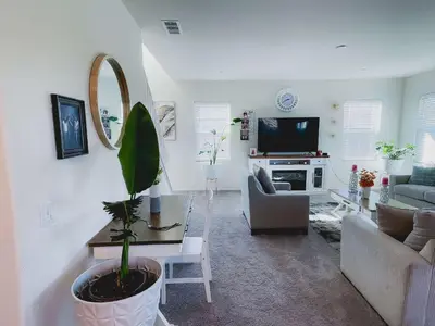 a living room with a potted plant and a couch at California 3-Bedroom Desert Escape With Garden in Victorville