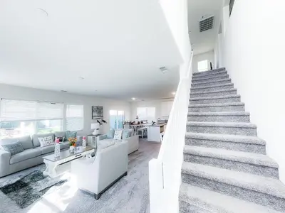 a white staircase in a living room with a couch at California 3-Bedroom Desert Escape With Garden in Victorville