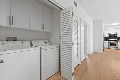 a white kitchen with white cabinets and a washer and dryer at The rose-Spacious 3-Bedroom Retreat in the Heart of Marina del Rey in Los Angeles