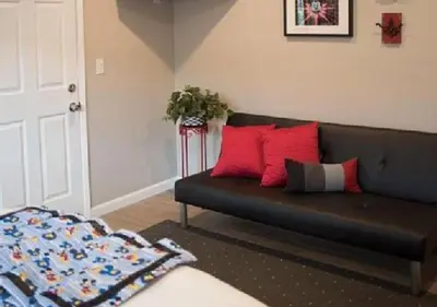 a living room with a black couch with red pillows at MagicwayVillas Paradise Pier Home - Across Disney in Anaheim