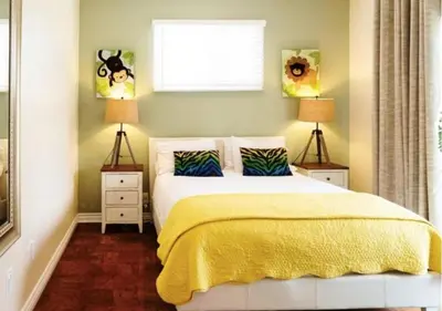 a bedroom with a bed with a yellow blanket and two lamps at MagicwayVillas LionQueen - Pool and Spa in Anaheim
