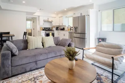 a living room with a couch and a table at Cozy LA Retreat Near USC Steps to Koreatown & Downtown in Los Angeles