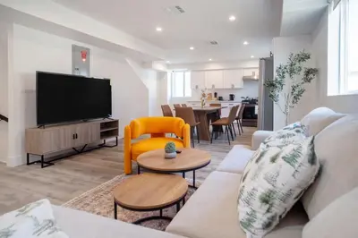 a living room with a couch and a flat screen tv at Cozy LA Retreat Near USC Steps to Koreatown & Downtown in Los Angeles