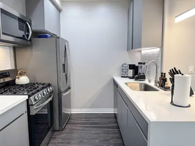 a kitchen with a stainless steel refrigerator and a sink at Bright & Spacious in Iconic LA Neighborhood Free parking - 10mins to Cedars in Los Angeles