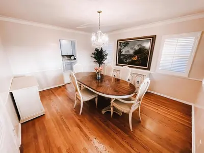 a dining room with a wooden table and chairs at Cozy 4BR home near SoFi in the City Of Champions in Inglewood