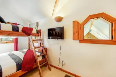 a bedroom with two bunk beds and a mirror at Calm Cozy 3BR cabin wAC, WiFi, Parking, BBQ in Cedar Glen