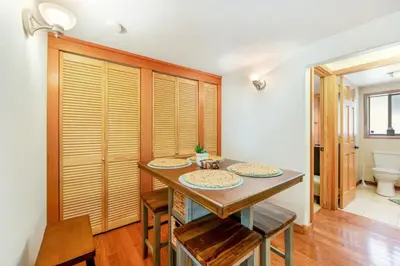 a dining room with a table and chairs and a toilet at Calm Cozy 3BR cabin wAC, WiFi, Parking, BBQ in Cedar Glen