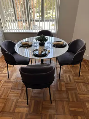 a dining room table with four chairs and a glass table with food at Warm and Welcoming in Los Angeles