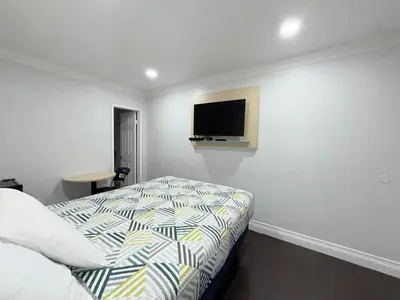 a bedroom with a bed and a tv on the wall at Uptown Inn in Long Beach