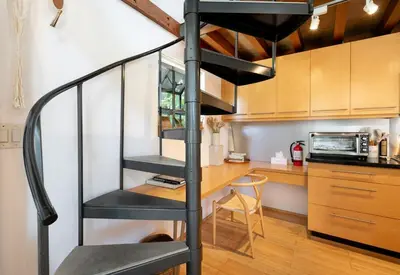 a spiral staircase in a kitchen with a desk at Private Venice Beach Loft - Steps to the Beach & Canals in Los Angeles