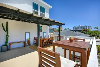 a patio with a wooden table and chairs at Private Venice Beach Loft - Steps to the Beach & Canals in Los Angeles
