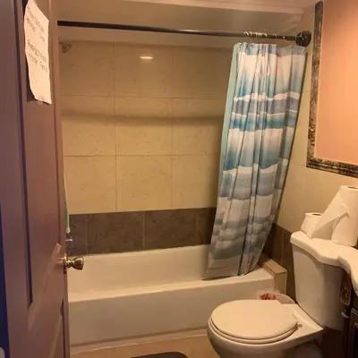 a bathroom with a toilet and a shower curtain at Cozy Room in Bakersfield