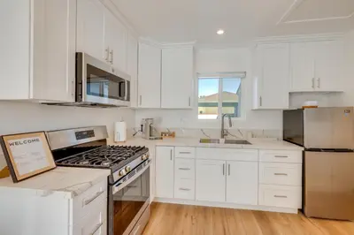 a kitchen with white cabinets and a stove top oven at 35 Mi to LA Modern Apartment in Chino! in Chino