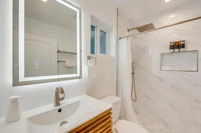 a white bathroom with a sink and a shower at 35 Mi to LA Modern Apartment in Chino! in Chino