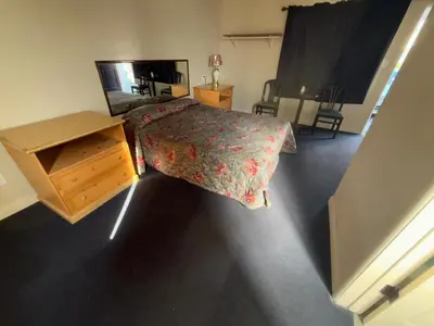 a bedroom with a bed and a dresser and a mirror at El Rancho Motel, Pasadena in Pasadena