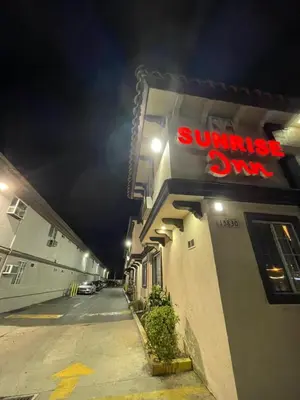 a sunset club sign on the side of a building at Sunrise Inn in Gardena
