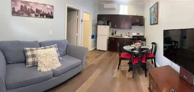 a living room with a couch and a table and a kitchen at Private Sanctuary in Montebello in Montebello