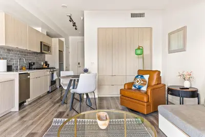 a kitchen and living room with a table and a chair at Modern Hollywood Studio, Pool Parking Gym in Los Angeles