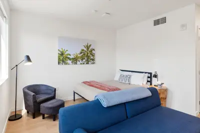 a bedroom with a bed and a blue couch at Bright Studio on Sunset Blvd Pool, Parking, Gym in Los Angeles