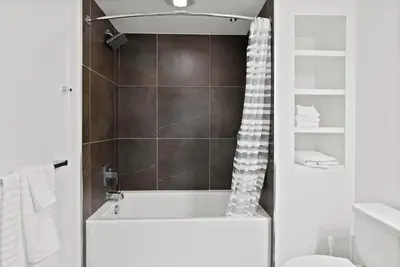 a bathroom with a bath tub and a toilet at Mid-Wilshire Studio Free Parking, Pool, Gym in Los Angeles