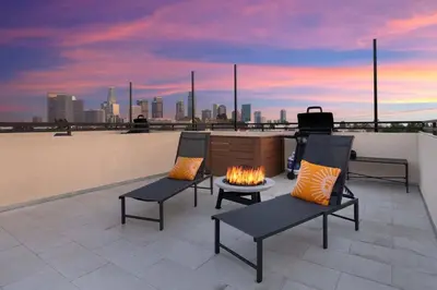 a rooftop patio with two chairs and a fire pit at LA Rooftop Paradise 2 in Los Angeles