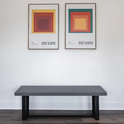 a black bench in front of two framed pictures at LA Rooftop Paradise 2 in Los Angeles