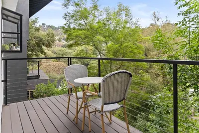 two chairs and a table on a balcony with a view at Designer Laurel Canyon Retreat, Hollywood Hills in Los Angeles