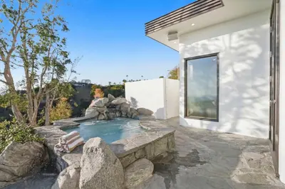 a backyard with a lap pool and a rock retaining wall at Serene by Stay Awhile Villas in Los Angeles