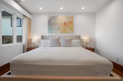 a bedroom with a large white bed with two lamps at Serene by Stay Awhile Villas in Los Angeles