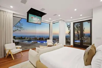 a bedroom with a white bed and a large window at Serene by Stay Awhile Villas in Los Angeles