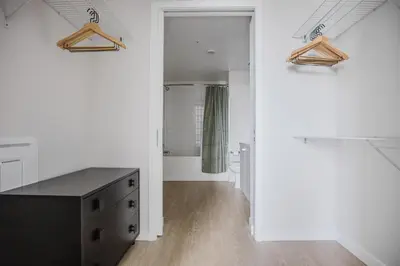 a bathroom with a black dresser in a white room at Blueground Downtown elevator nr parks LAX-1238 in Los Angeles