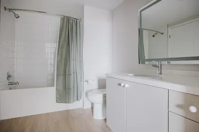 a white bathroom with a toilet and a sink at Blueground Downtown elevator nr parks LAX-1238 in Los Angeles