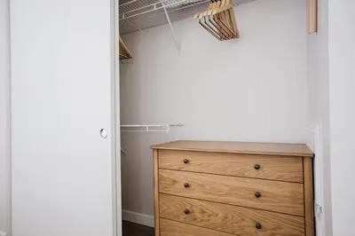a bedroom with a wooden dresser and a closet at Blueground Downtown elevator nr parks LAX-1239 in Los Angeles