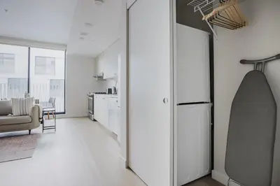 a white kitchen with a couch and a refrigerator at Blueground Downtown elevator nr parks LAX-1239 in Los Angeles