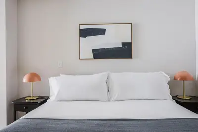 a bedroom with a white bed with two lamps at Blueground Downtown elevator nr parks LAX-1239 in Los Angeles