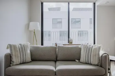 a couch in a living room with a large window at Blueground Downtown elevator nr parks LAX-1239 in Los Angeles