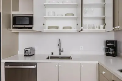 a kitchen with white cabinets and a sink and a microwave at Blueground Downtown elevator nr parks LAX-1240 in Los Angeles