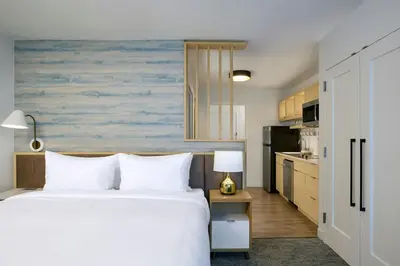 a bedroom with a bed and a kitchen at TownePlace Suites by Marriott Palmdale in Palmdale