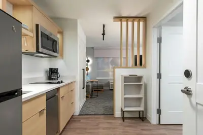 a kitchen with white countertops and a door to a room at TownePlace Suites by Marriott Palmdale in Palmdale