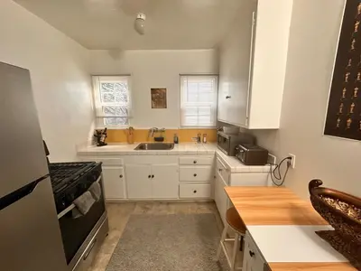 a kitchen with white cabinets and a sink at Del in Los Angeles