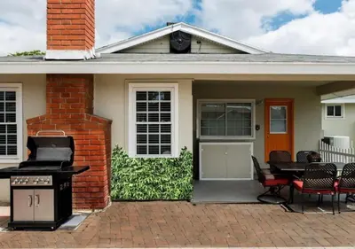 a house with a grill and a table and chairs at Tiki House and Spa - Walking Distance to Dsineyland in Anaheim