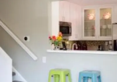 a kitchen with white cabinets and two blue stools at MagicwayVillas Micky's Fireworks Pool & Spa - Across Disneyland in Anaheim