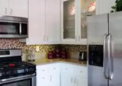 a kitchen with white cabinets and a stainless steel refrigerator at MagicwayVillas Micky's Fireworks Pool & Spa - Across Disneyland in Anaheim