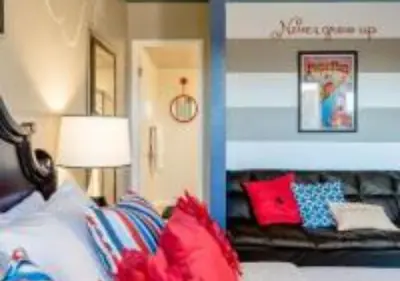 a bedroom with a bed with red and blue pillows at Magicway Villas Mini's Poolside and Spa - Across Disneyland in Anaheim